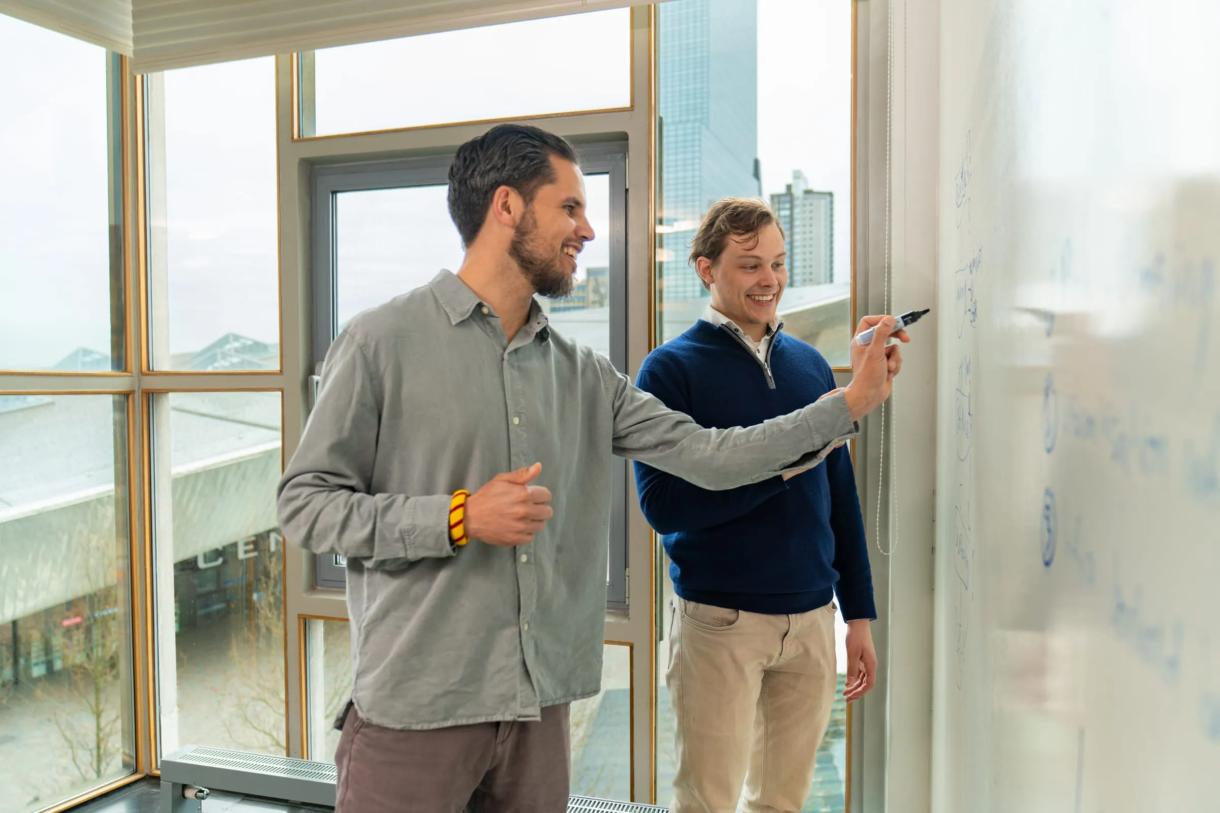 Twee Florence-collega's werken samen aan een whiteboard
