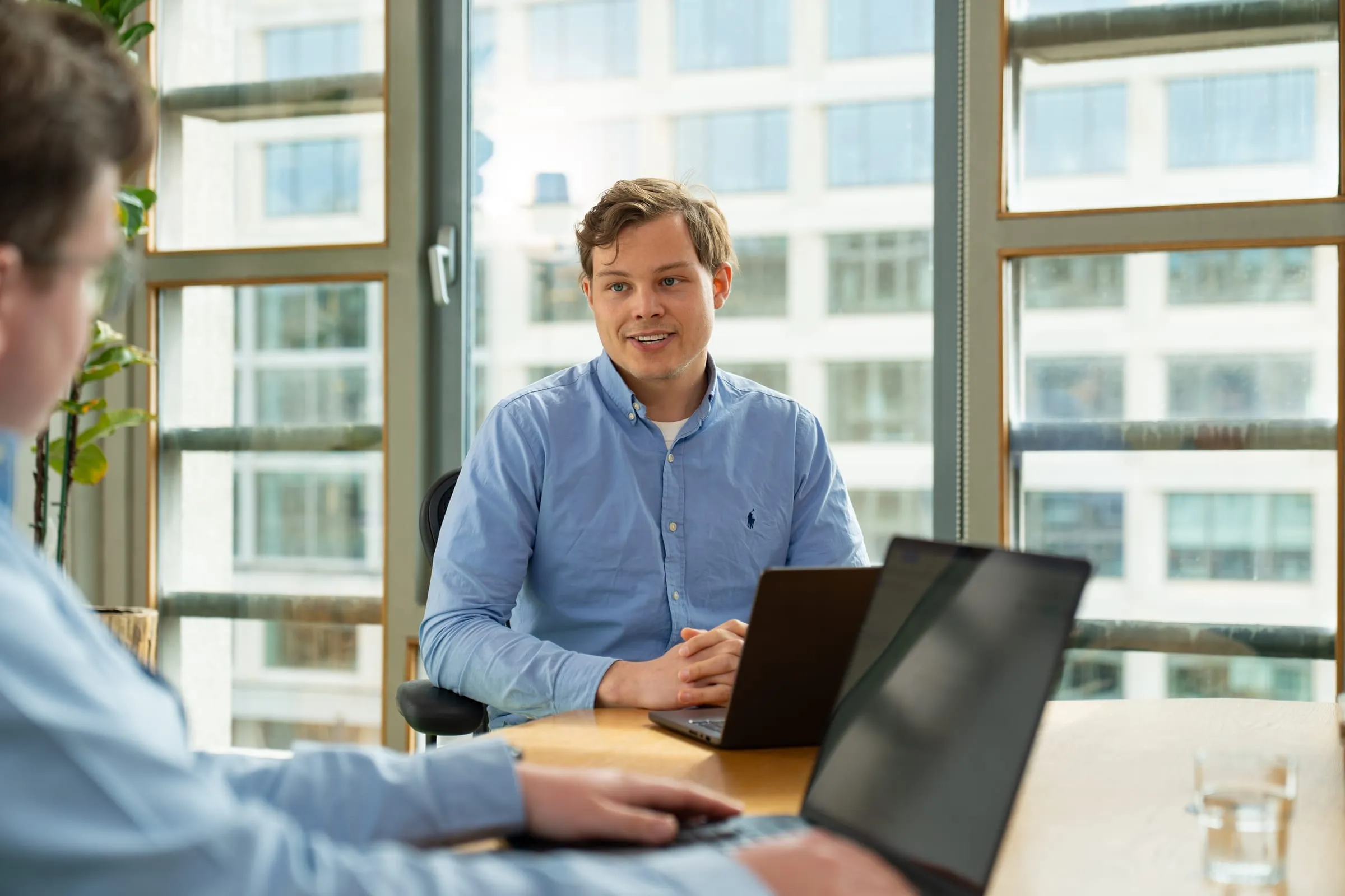 Twee Florence-collega's in gesprek aan een bureau met laptops